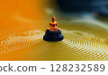 Golden Buddha figurine surrounded by concentric ripples in tranquil water at a serene location 128232589