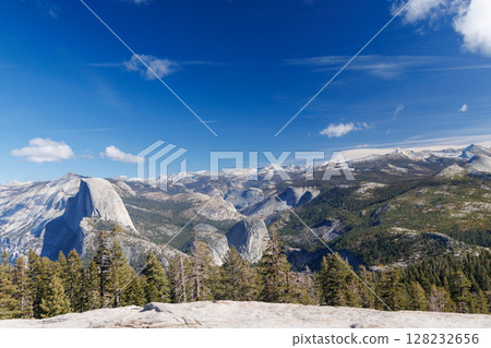 Mountain landscape in Yosemite National Park with towering granite cliffs, green forests 128232656