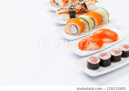 Assorted sushi and maki rolls beautifully arranged on plates 128232685