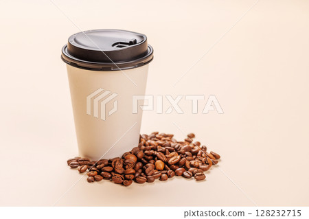 A paper cup of freshly brewed coffee surrounded by rich, aromatic roasted coffee beans 128232715