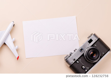 Travel-themed flat lay with blank photo card, camera, toy airplane 128232738