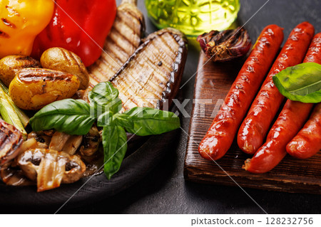 Assorted grilled vegetables including bell peppers, zucchini, eggplant, and sausages 128232756