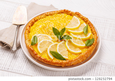 Delicious lemon tart with golden crust and smooth, glossy lemon filling 128232794