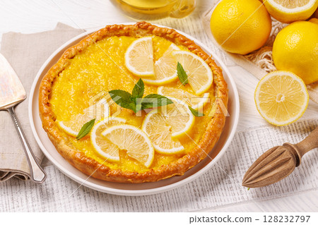 Delicious lemon tart with golden crust and smooth, glossy lemon filling 128232797