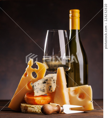Assorted cheeses paired with glass of wine on a rustic table Assorted cheeses paired with glass of wine on a rustic table 128232810