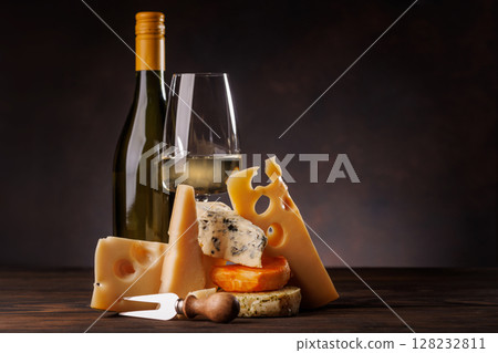 Assorted cheeses paired with glass of wine on a rustic table Assorted cheeses paired with glass of wine on a rustic table 128232811