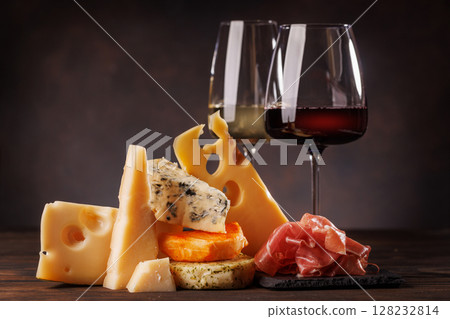 Assorted cheeses paired with glasses of wine on a rustic table Assorted cheeses paired with glasses of wine on a rustic table 128232814