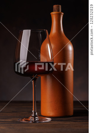 Wine glass filled with wine beside a bottle Wine glass filled with wine beside a bottle 128232819