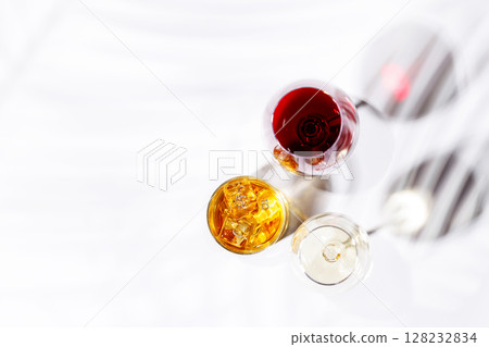A refined composition of wine glasses filled with red and white wine, paired with a whiskey glass 128232834