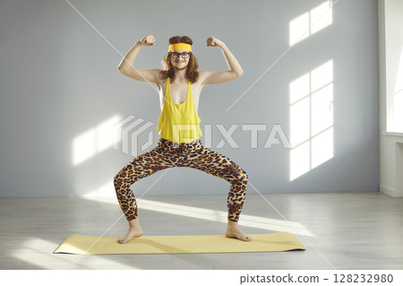 Happy thin athlete in funny retro fitness wear smiling and doing sports exercise Happy thin athlete in funny retro fitness wear smiling and doing sports exercise 128232980