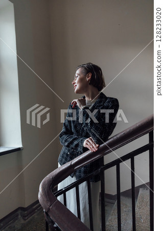 Fashionable woman in skirt and jacket climbing stairs 128233020