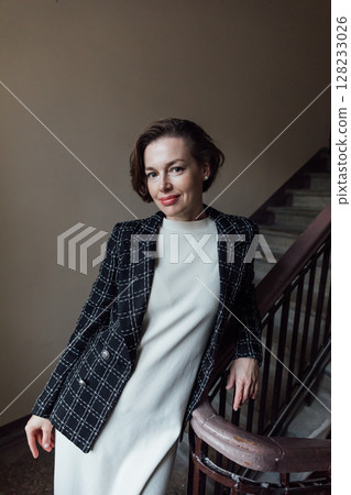 Fashionable woman in skirt and jacket climbing stairs Fashionable woman in skirt and jacket climbing stairs 128233026