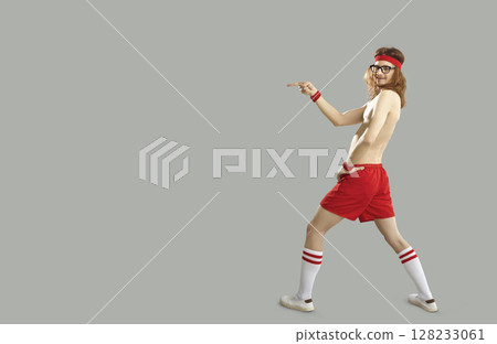 Funny shirtless thin man in sports shorts pointing with finger to advertising copy space Funny shirtless thin man in sports shorts pointing with finger to advertising copy space 128233061