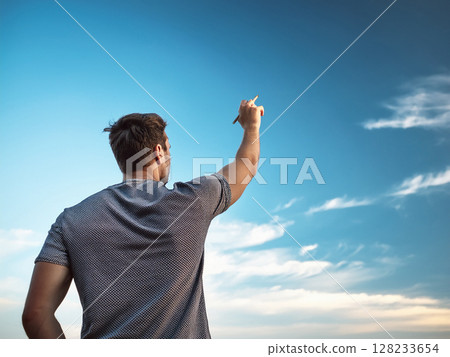 藍天下，一名男子高舉筆 128233654