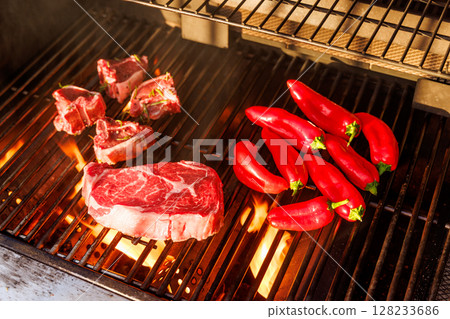 Juicy steaks and bell peppers sizzling on a grill Juicy steaks and bell peppers sizzling on a grill 128233686