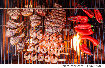 Juicy steaks and bell peppers sizzling on a grill Juicy steaks and bell peppers sizzling on a grill 128233689