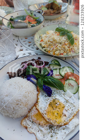 Sumptuous Filipino breakfast spread featuring rice, fried eggs, bistek or karne frita with bowls of chicken adobo and tinola soup. Authentic local food from the Philippines 128233926