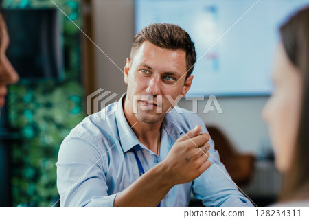 Young businessman eating healthy salad lunch with colleagues in modern office cafeteria Young businessman eating healthy salad lunch with colleagues in modern office cafeteria 128234311