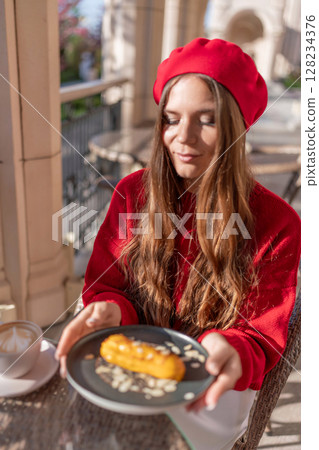 Woman Beret Eclair: Eating dessert at an outdoor cafe during a sunny morning, casual style. 128234376