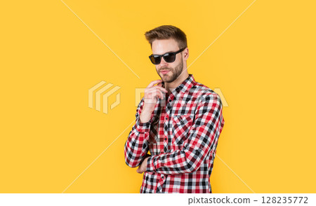 young handsome guy in checkered shirt and glasses. stylish male wear casual clothes. bearded man with bristle on unshaven face. fashion and beauty. barbershop concept. mens wear. Loving new style young handsome guy in checkered shirt and glasses. stylish male wear casual clothes. bearded man with bristle on unshaven face. fashion and beauty. barbershop concept. mens wear. Loving new style 128235772