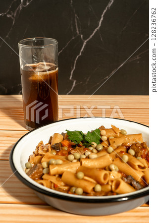 Delicious pasta with meat and peas served with soda on wooden table 128236762