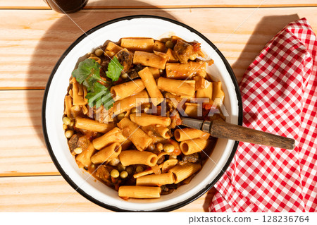 Delicious pasta with meat and vegetables served in rustic enamelware bowl Delicious pasta with meat and vegetables served in rustic enamelware bowl 128236764