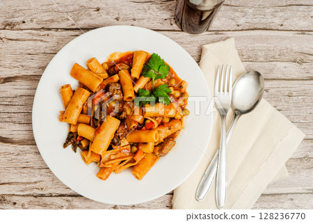 Delicious pasta with beef stew, vegetables and parsley on rustic wooden table Delicious pasta with beef stew, vegetables and parsley on rustic wooden table 128236770
