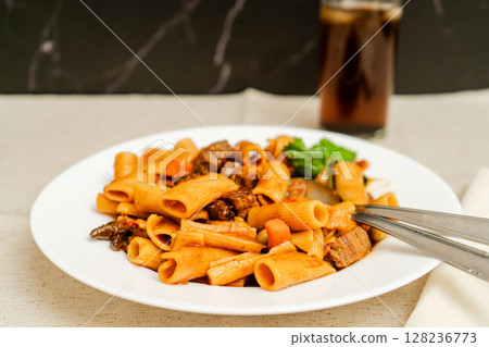 Delicious pasta with beef and vegetables enjoying a refreshing drink Delicious pasta with beef and vegetables enjoying a refreshing drink 128236773