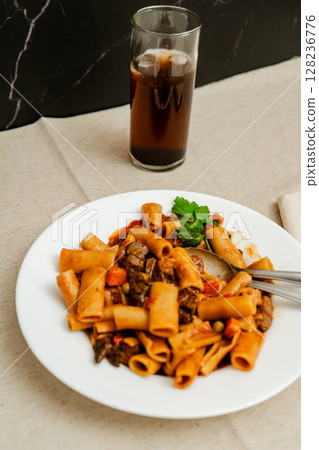 Delicious pasta with beef and vegetables served with soda Delicious pasta with beef and vegetables served with soda 128236776