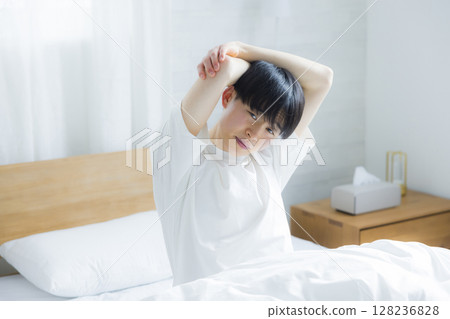 Young man stretching in bed Young man stretching in bed 128236828