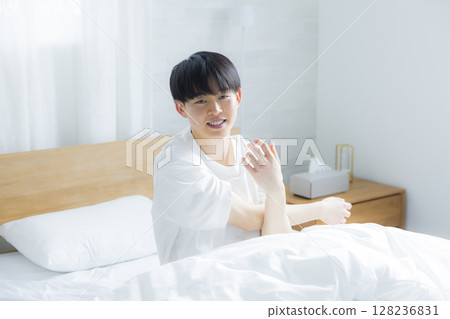 年輕人在床上伸展身體 年輕人在床上伸展身體 128236831