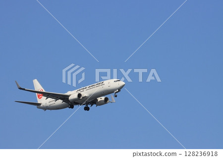一架客機在藍天背景下降落，一架日航飛機正在進場 128236918