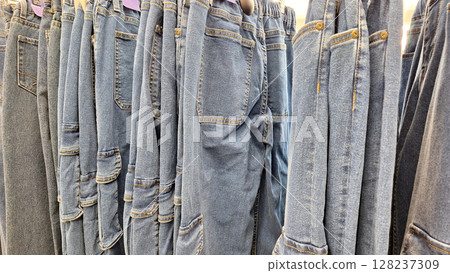 Variety of denim jeans hanging in a clothing store display 128237309