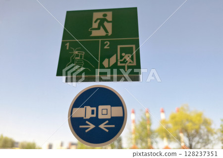 Emergency exit and seatbelt signs on clear sky background 128237351