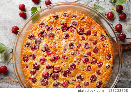 Homemade cherry clafoutis pie with fresh berries and vanilla close-up in a baking dish. Horizontal top view Homemade cherry clafoutis pie with fresh berries and vanilla close-up in a baking dish. Horizontal top view 128238868