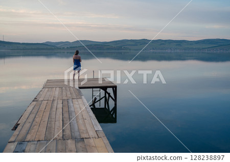 Woman in Blue Towel Sitting on Dock 128238897