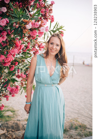 Smiling Woman in Elegant Dress by the Beach 128238903