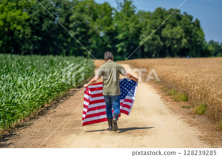 Flag of USA. Independence day. Man in field. Hispanic man with American flag in crop field. Independence day of America. 4th of July. American labor day. American flag and man farmer 128239285