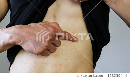 Man pointing to his stomach Man pointing to his stomach 128239444
