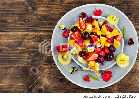 Appetizing summer fruit salad on rustic wooden table. Appetizing summer fruit salad on rustic wooden table. 128239820