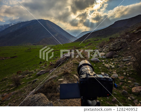 Camera capturing photograph in serene mountain valley Camera capturing photograph in serene mountain valley 128240952