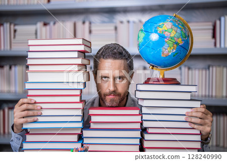 Knowledge and education concept. school teacher with book in classroom. teacher in classroom. Teachers Day. Tutor at classroom. Man geographer with books in classroom. Page turner Knowledge and education concept. school teacher with book in classroom. teacher in classroom. Teachers Day. Tutor at classroom. Man geographer with books in classroom. Page turner 128240990