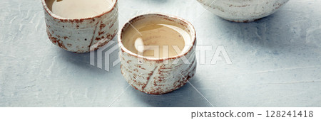 Sake ochoko, traditional cup, on a slate background, a close-up Sake ochoko, traditional cup, on a slate background, a close-up 128241418