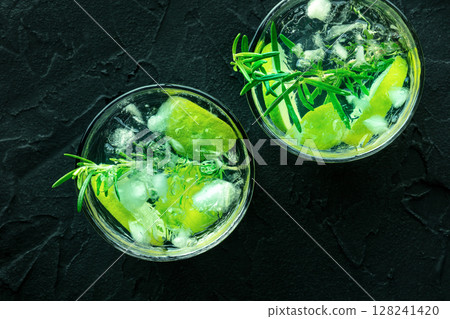 Gin tonic, top shot with rosemary and lime. Fresh summer cocktail with ice Gin tonic, top shot with rosemary and lime. Fresh summer cocktail with ice 128241420