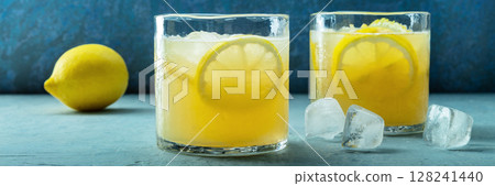 Glasses of lemonade panorama, a mocktail with lemon juice, on a blue background Glasses of lemonade panorama, a mocktail with lemon juice, on a blue background 128241440