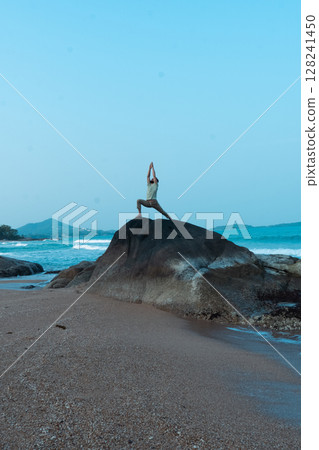 Experience Serenity in Nature A Yoga Pose Performed on a Coastal Rock Amidst Stunning Scenery 128241450