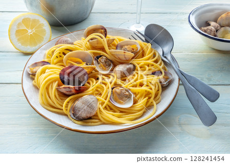 Vongole clams with spaghetti pasta, with lemon, with a wine glass Vongole clams with spaghetti pasta, with lemon, with a wine glass 128241454