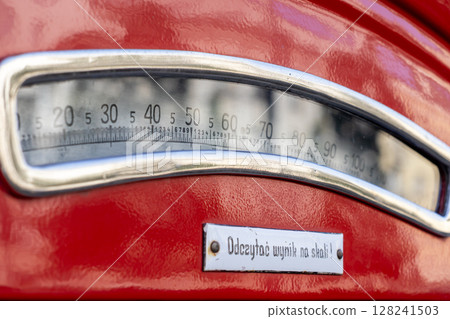 Red vintage weighing scale displaying numerical measurements from 0 to 100, featuring a Polish instruction Read the result on the scale reflecting accuracy and historical significance Red vintage weighing scale displaying numerical measurements from 0 to 100, featuring a Polish instruction Read the result on the scale reflecting accuracy and historical significance 128241503
