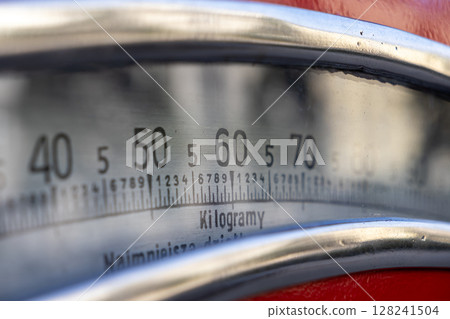 Close-up of an old industrial weighing scale dial, clearly displaying Kilogramy (Kilograms) units and markings for precise weight measurement and commercial accuracy Close-up of an old industrial weighing scale dial, clearly displaying Kilogramy (Kilograms) units and markings for precise weight measurement and commercial accuracy 128241504