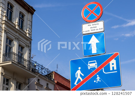 Stacked European road signs clearly regulate urban traffic flow, showing a no parking zone with delivery exception and residential area end 128241507
